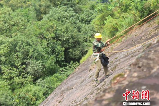 丹霞赤壁上的环卫者 用生命守护珍贵自然遗产